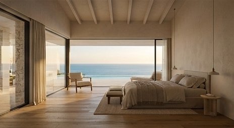 Master bedroom opening through glass walls onto a sea-view terrace
